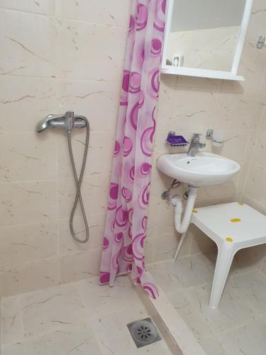 a bathroom with a sink and a shower curtain at Apartmani NAR in Sutomore