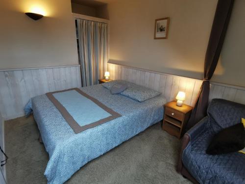 1 dormitorio con 1 cama, 1 sofá y 2 lámparas en Lac Annecy plage privée, Duplex Baie des voiles, en Duingt