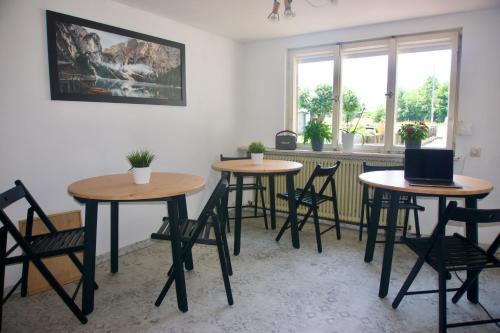 trzy stoły i krzesła w pokoju z oknem w obiekcie Mountain Hostel City w mieście Oberstdorf