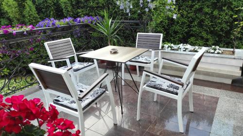 a table and four chairs and a table and flowers at Vila Sentić in Vranje