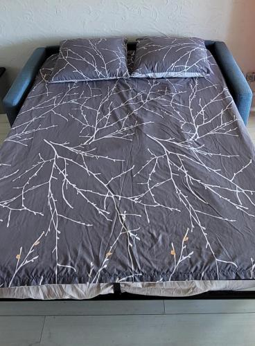 un lit avec une couette noire avec des toiles d'araignées blanches dans l'établissement Studio Piscine à 5 minutes des plages du couchant, à La Grande Motte