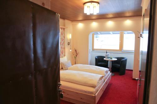 a small bedroom with a bed and a window at Hotel Metzgerwirt in Fieberbrunn