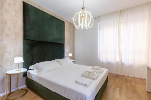 ein Schlafzimmer mit einem großen Bett und einem Kronleuchter in der Unterkunft ALMi in Cagliari
