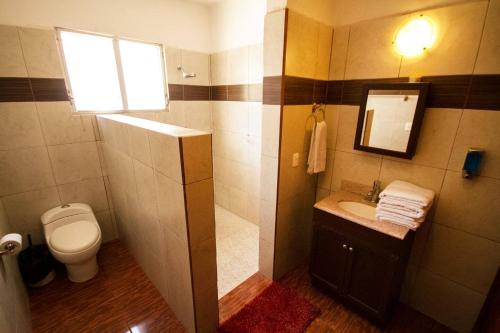 uma casa de banho com um WC, um lavatório e uma janela em Departamento céntrico, perfectamente ubicado, dos habitaciones em Cancún
