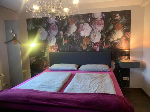 a bedroom with a large bed with a floral wall at landpension-dette in Berlingerode
