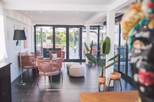 a lobby with chairs and a table and a plant at Taormina Palace Hotel in Taormina