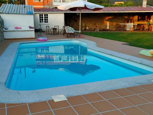 a swimming pool with blue water in a yard at Eirixo in Valga