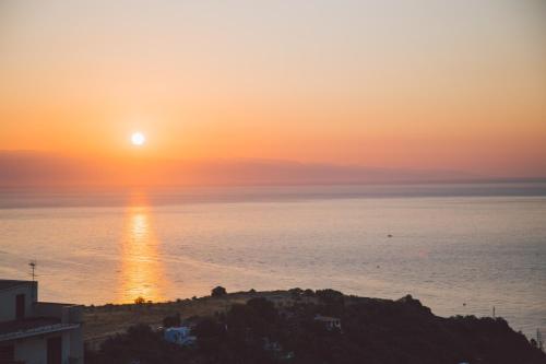a sunset over the ocean with the sun on the horizon at Taormina Palace Hotel in Taormina
