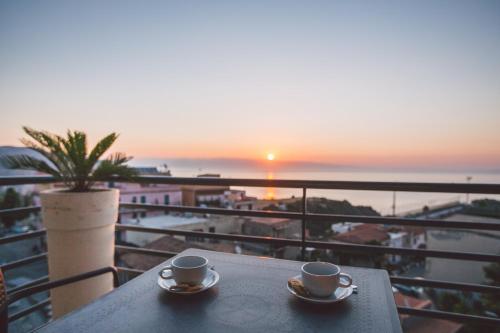two cups of coffee on a table with a view of the ocean at Taormina Palace Hotel in Taormina