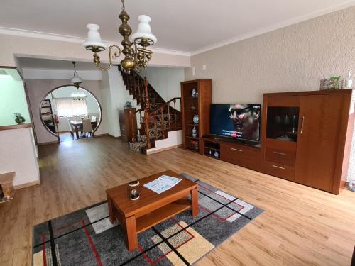 a living room with a table and a tv at Gomes & Fortunato House in Casais Brancos