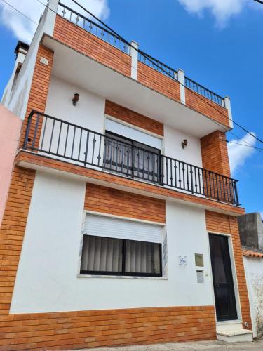 a building with a balcony on top of it at Gomes & Fortunato House in Casais Brancos