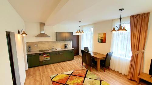 eine Küche und ein Wohnzimmer mit einem Tisch und einem Esszimmer in der Unterkunft Zur Krone Aparthotel in Widdershausen