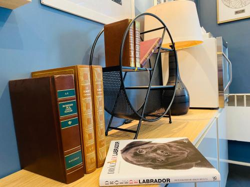 a stack of books sitting on a shelf next to a table at Hôtel Clairefontaine in Paris