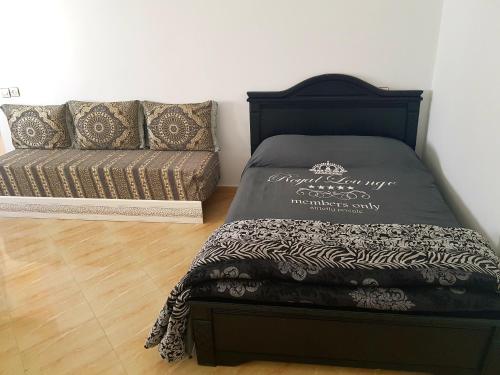 uma cama e um sofá num quarto em luxe appartement Nour D'asilah 3 Free WiFi 5G em Asilah