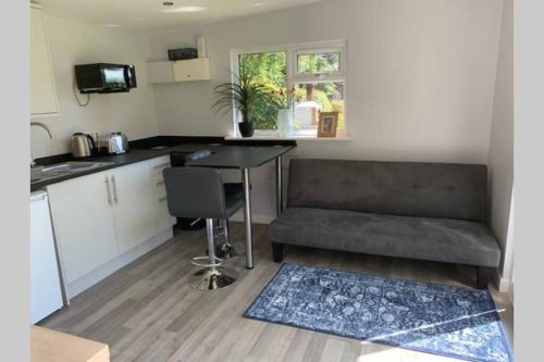 a kitchen with a couch and a table in a room at Independent garden studio - sleeps max 3. in Derby