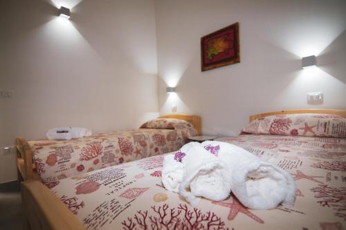 a bedroom with two beds with stuffed animals on the bed at La terra del benessere in Castelsardo