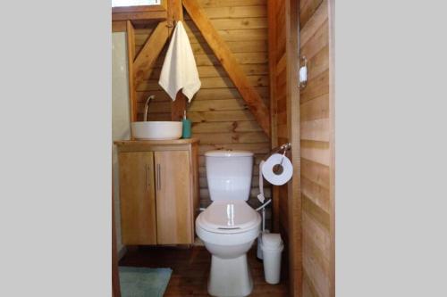a bathroom with a toilet in a log cabin at La Casa En El Bosque in El Retiro