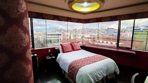 a bedroom with a bed with a view of a city at Hotel Mary Carmen in Ambato