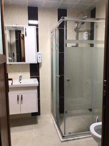 a bathroom with a glass shower and a sink at Kusva Apart in Uzungöl