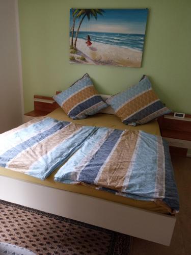 1 cama con 2 almohadas y una foto de la playa en Private Wohnung Biop, en Kassel
