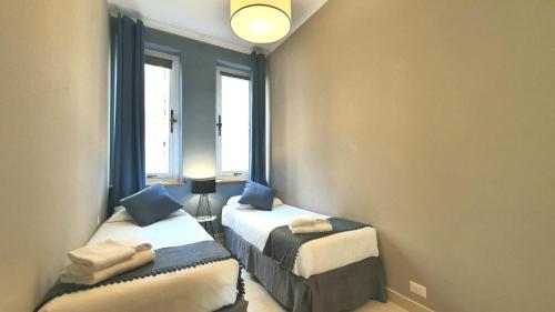 a small room with two beds and a window at Heart Milan Apartments Fashion District in Milan