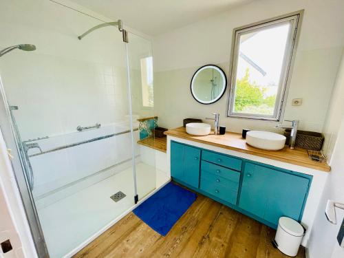 a bathroom with two sinks and a shower at Villa Simone vue mer 2min à pied de la plage in Saint-Lunaire