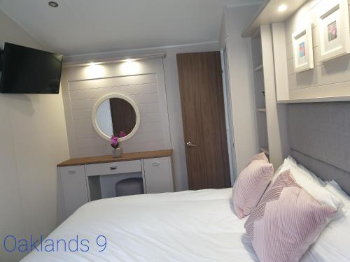 sypialnia z białym łóżkiem i lustrem w obiekcie Modern Sea View Holiday Home Isle of Wight w mieście Porchfield