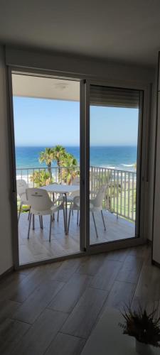 a balcony with a table and chairs and a view of the ocean at Estudio SHEILA in Torrox Costa