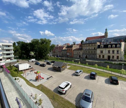 a parking lot with cars parked in a city at Sunrise Apart in Jelenia Góra