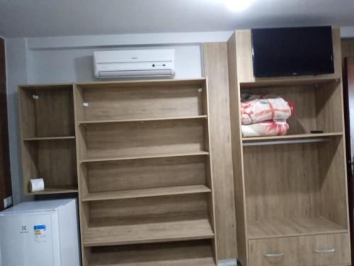 a closet with wooden shelves and a television in it at Pousada Mar e Cia in Ilha do Mel