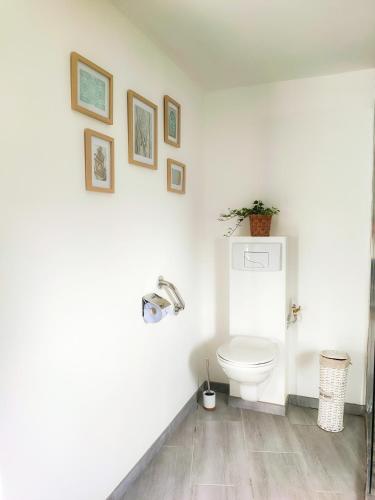 La salle de bains est pourvue de toilettes et de photos murales. dans l'établissement Émeraude, à Penmarcʼh