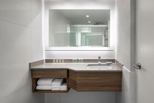 a bathroom with a sink and a mirror at SENS Høtel in Montréal
