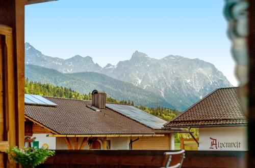 a view of a house with mountains in the background at Pension Krüner Stub´n in Krün