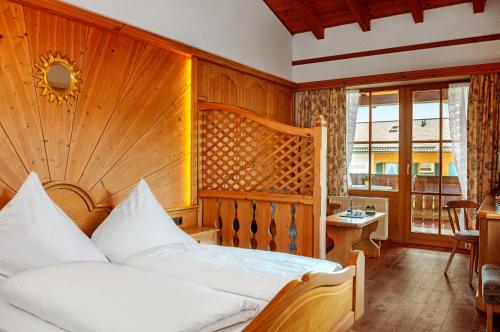 a bedroom with a bed with a wooden wall at Pension Krüner Stub´n in Krün