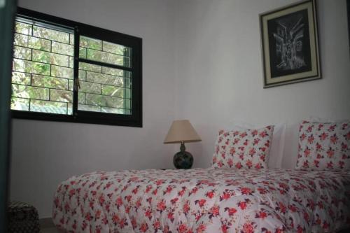 een slaapkamer met een bed met een rood dekbed en een raam bij Maison Etoile De Mer 1 in Skhirat