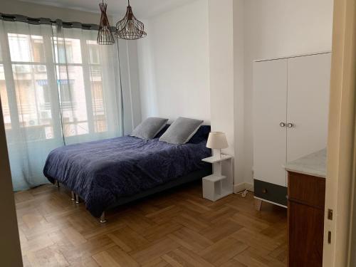 une chambre avec un lit avec une couette bleue dans l'établissement Promenade des Anglais à côté du Negresco, à Nice