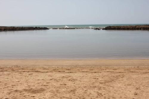 a sandy beach with a body of water at Maison Etoile De Mer 2 in Skhirat