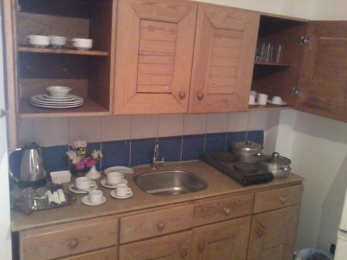 encimera de cocina con fregadero y armarios de madera en Logaina Sharm Resort Apartments, en Sharm El Sheikh