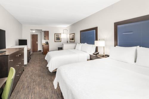 a hotel room with two beds and a desk at Holiday Inn Express & Suites Wilmington-Newark by IHG in Newark