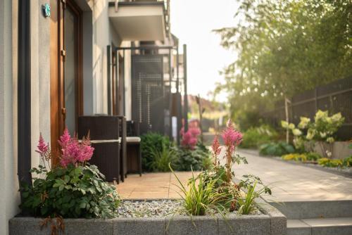 a garden with flowers in front of a building at Błękitne Wzgórze - Nowoczesne Pokoje Gościnne in Władysławowo
