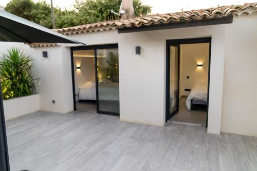 a patio with sliding glass doors leading to a bedroom at Villa 6 pers à 30m de la mer in Sainte-Maxime