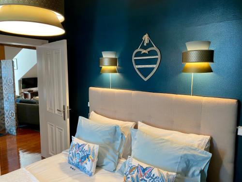 a bedroom with a bed with blue walls and two lamps at Studios with Mezzanine Rua da Moeda in Lisbon