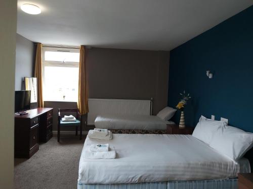Cette chambre comprend 2 lits et une fenêtre. dans l'établissement Midlands Hotel, à Mansfield