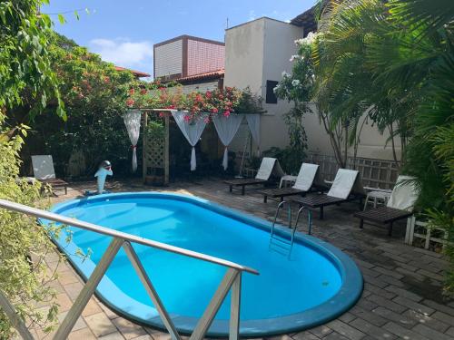 a small blue pool with chairs in a courtyard at Pousada Beijos y Abraços in Natal