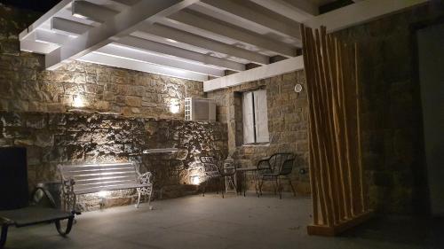 a room with chairs and a stone wall at Mykonos Double Luxury Mini Suites-With External Hot spa Adults only in Ano Mera