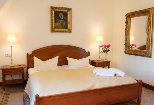 a bedroom with a large bed with a mirror at Schlosshotel zum Markgrafen in Quedlinburg