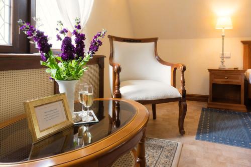 a living room with a table and a vase of flowers at Schlosshotel zum Markgrafen in Quedlinburg