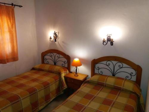1 dormitorio con 2 camas y una lámpara en una mesa en Room in Guest room - Casa El Cardon A2 Buenavista del Norte, en Buenavista del Norte