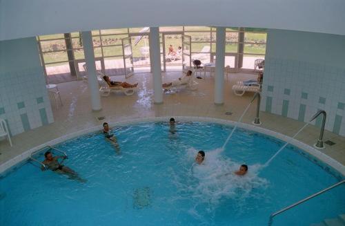 a group of people swimming in a swimming pool at Hotel Restaurant des Thermes in Castéra-Verduzan