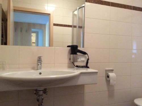 a bathroom with a sink and a hair dryer at Zimmervermietung Babsy in Zell am See